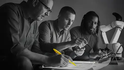 3 men looking over a document laid out on a desk